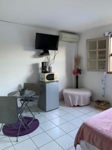een kamer met een bed, een tafel en een tv bij Ladoré in Montjoly