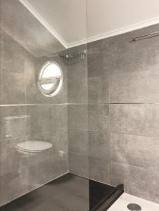 La salle de bains est pourvue de toilettes et d'une fenêtre ronde. dans l'établissement BLUE HOUSE SESIMBRA with parking, à Sesimbra