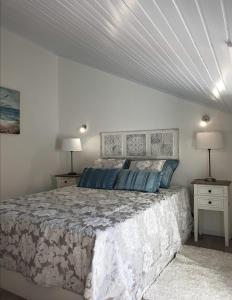 une chambre avec un lit et deux tables de nuit avec lampes dans l'établissement BLUE HOUSE SESIMBRA with parking, à Sesimbra