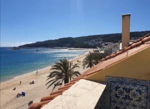 Blick auf den Strand und das Meer von einem Gebäude in der Unterkunft BLUE HOUSE SESIMBRA with parking in Sesimbra