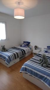 - deux lits dans une chambre avec des ours en peluche dans l'établissement Plaisir en baie, à Saint-Blimont