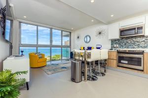 a kitchen with a view of the ocean at Breath Taking Beach Front Views Condo Eagle Beach in Palm-Eagle Beach