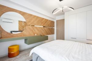 a bedroom with a white bed and a mirror at Classy Sassy I Timpuri Noi in Bucharest