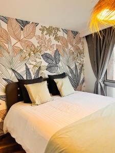 a bedroom with a large bed with a floral wall at Appartement 2 chambres avec parking in Pontarlier