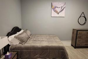 1 dormitorio con cama, espejo y tocador en Retreat Suite 1 - Cozy Downtown Getaway en Grand Rapids