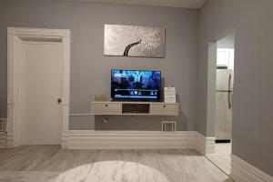 Retreat Suite 1 - Cozy Downtown Getaway في غراند رابيدز: غرفة معيشة فيها تلفزيون على جدار