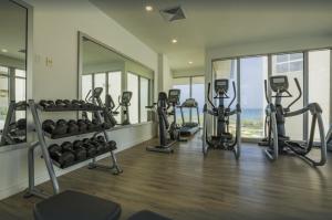 un gimnasio con cintas de correr y equipos de ejercicio en un edificio en Breath Taking Beach Front Views Condo Eagle Beach en Palm-Eagle Beach