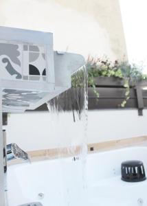 a water fall from a faucet over a sink at day&night Luxury Apartment, 2 Bedrooms, Terrace, Jacuzzi outdoor, Parking in Trieste