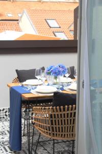 a table with chairs and a blue table cloth on it at day&night Luxury Apartment, 2 Bedrooms, Terrace, Jacuzzi outdoor, Parking in Trieste