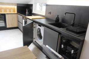 a kitchen with a sink and a washing machine at day&night Luxury Apartment, 2 Bedrooms, Terrace, Jacuzzi outdoor, Parking in Trieste