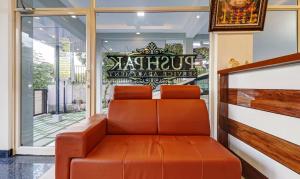 an orange leather bench in front of a window at Treebo Trend Pushpak in Cochin