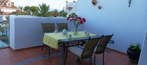 una mesa con un jarrón de flores en el balcón en MIRADOR DEL OLIVO BEACH, en Almuñécar