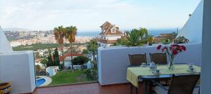 balcón con mesa y vistas a la ciudad en MIRADOR DEL OLIVO BEACH, en Almuñécar