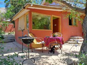 a house with a table and a cat sitting in front of it at El Jardín Secreto-Pisco Elqui in Pisco Elqui