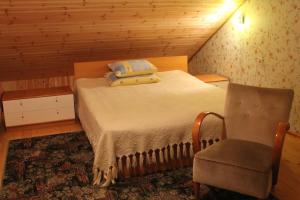 a small bedroom with a bed and a chair at Aikarali Home Accommodation in Haapsalu
