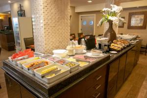 un buffet con molti cibi diversi su un tavolo di Roochelle Hotel by Nobile a Curitiba