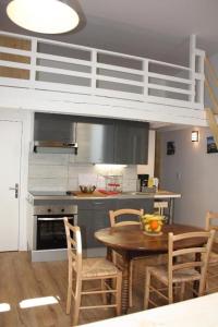 ボルドーにあるLe Clos Beaufleuryのキッチン(テーブル、椅子付)、ロフトベッド1台が備わります。