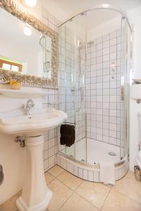 a white bathroom with a shower and a sink at Appartement Graf in Lech am Arlberg