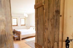 um quarto com uma cama e uma porta de madeira em Appartement Graf em Lech am Arlberg
