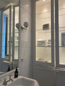 une salle de bain avec un lavabo, un miroir et des serviettes dans l'établissement Villa Georges - La Rochelle centre -, à La Rochelle 39 autres photos