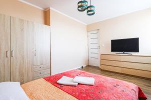 sypialnia z łóżkiem i telewizorem na ścianie w obiekcie Apartament Morena z widokiem z tarasu na morze w Świnoujściu