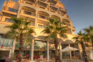 un bâtiment avec des palmiers en face de celui-ci dans l'établissement Bella Vista Hotel, à San Pawl il-Baħar