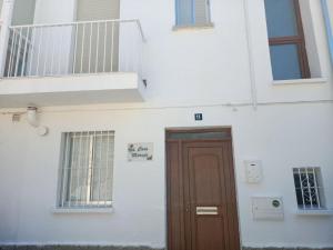 een wit gebouw met een bruine deur en een trap bij CASA MARUJA in Avila
