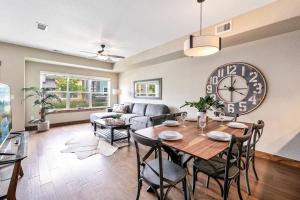 a living room with a table and a large clock at Spectacular Home near Breweries & River District! in Fort Collins