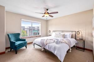 a bedroom with a bed and a chair and a window at Spectacular Home near Breweries & River District! in Fort Collins