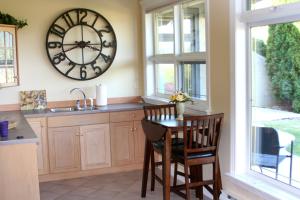 a kitchen with a table and a large clock on the wall at Quail Ridge in Kelowna