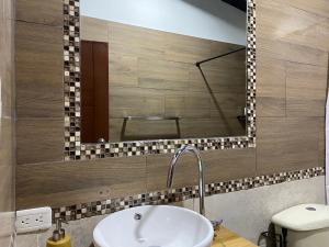 a bathroom with a sink and a mirror at Premium Holiday Cabin - spectacular Tungurahua volcano view in Baños