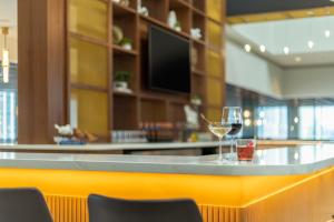 a bar with a glass of wine on a counter at voco Chicago Downtown - Riverwalk by IHG in Chicago +135 photos