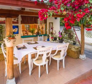 - une table blanche avec des chaises et des fleurs sur la terrasse dans l'établissement Casa Elalu, à Quito