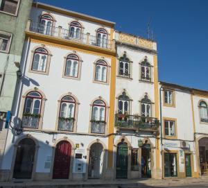 a building with a lot of windows and balconies at Thomar Story - Guest House in Tomar