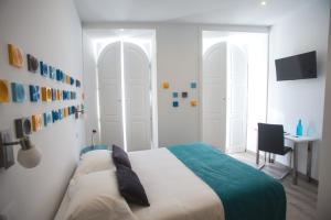 a bedroom with a bed and a desk at Thomar Story - Guest House in Tomar