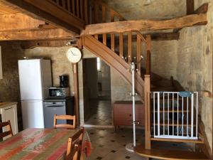 uma cozinha com uma escada e um relógio na parede em La Source Gilhodes em Castelnau-de-Mandailles