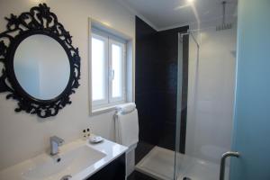 a bathroom with a sink, mirror, and bathtub at Thomar Story - Guest House in Tomar