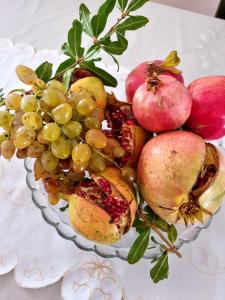 a bowl of fruit with apples and pomegranates at Apartments Maria in Ivanica