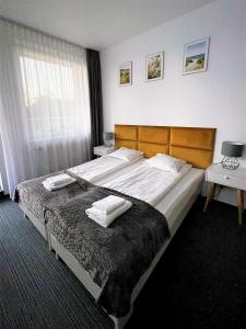1 dormitorio con 1 cama grande y 2 toallas. en Apartamenty Planeta Mielno, en Mielno