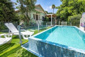 a swimming pool with two chairs and a house at Bikta Baglil in Shomera