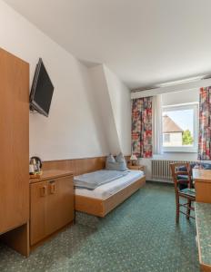 a hotel room with a bed and a tv at Hotel Kniestedter Hof in Salzgitter-Bad