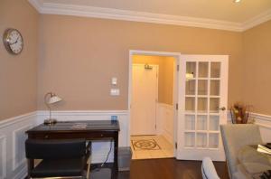 an office with a desk and a clock on a wall at The SoMa Furnished Residences in Hamilton