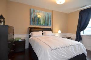 1 dormitorio con 1 cama y una pintura en la pared en The SoMa Furnished Residences en Hamilton