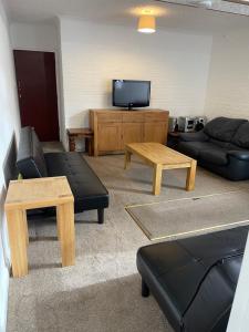 a living room with a couch and a tv at Spacious 9 bed house in Mansfield Nottinghamshire in Mansfield