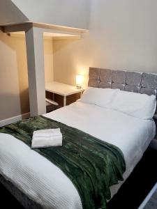 - une chambre avec un grand lit blanc et un bureau dans l'établissement MM Sure Stay Accommodation - NG1, à Nottingham