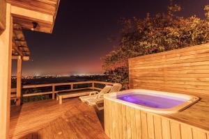 una bañera de hidromasaje en una terraza de madera por la noche en Chalés e Bangalôs Ibiraquera, en Praia do Rosa