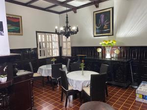 un comedor con mesas y sillas y una lámpara de araña en Hotel Casa Colonial, en Barranquilla