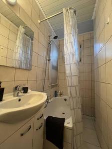 Cosy Apartment Merode في بروكسل: حمام مع حوض ودش وحوض استحمام