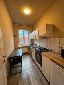 a kitchen with white cabinets and a stove top oven at Cosy Apartment Merode in Brussels