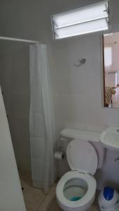 Un baño blanco con inodoro y lavabo. en Caá Guazú, en Curuzú Cuatiá